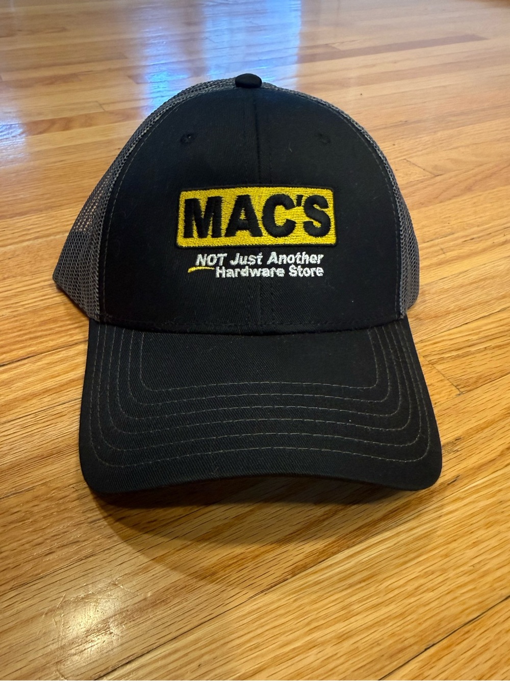 Mac’s Not Just Another Hardware Store Black Trucker Cap with Yellow Logo